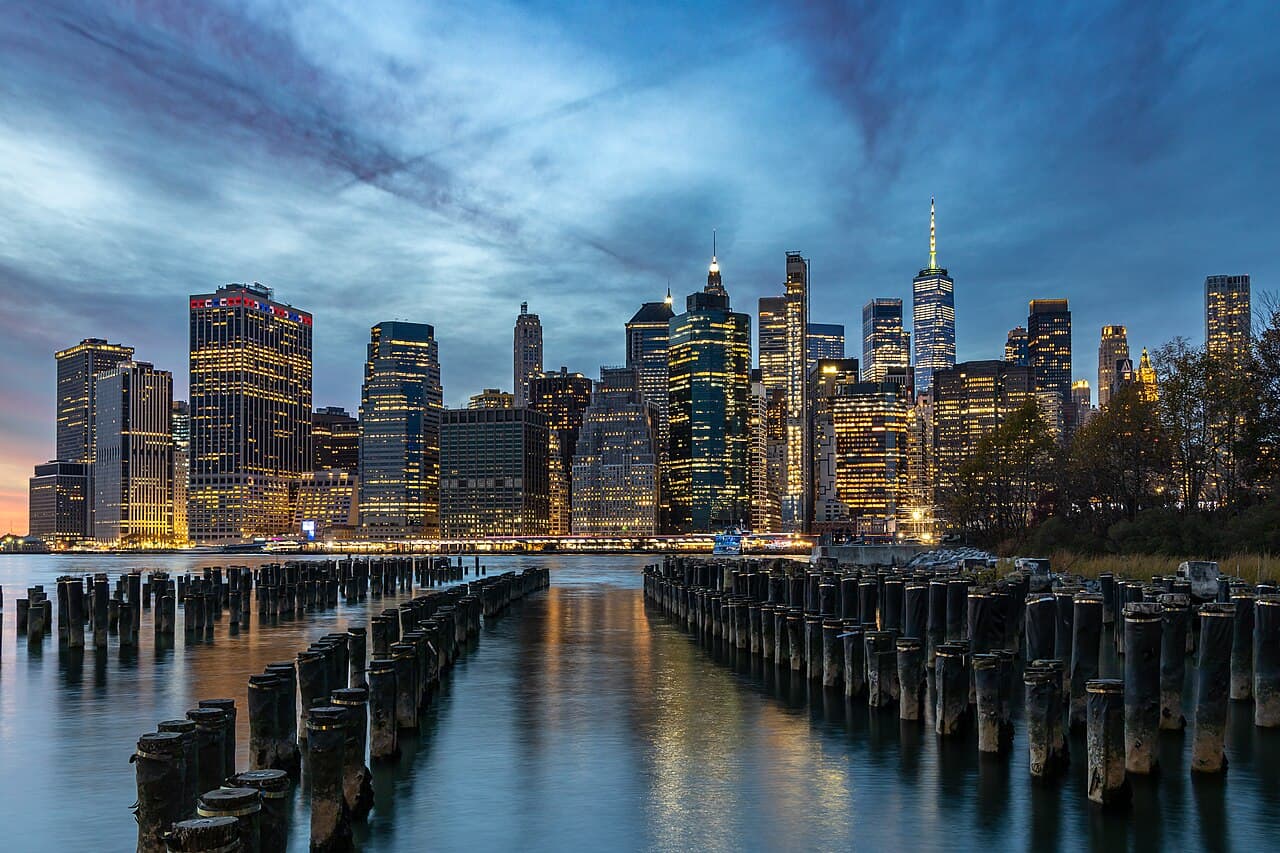 The Lower Manhattan skyline at dusk seen across the East River, One World Trade Center at center.